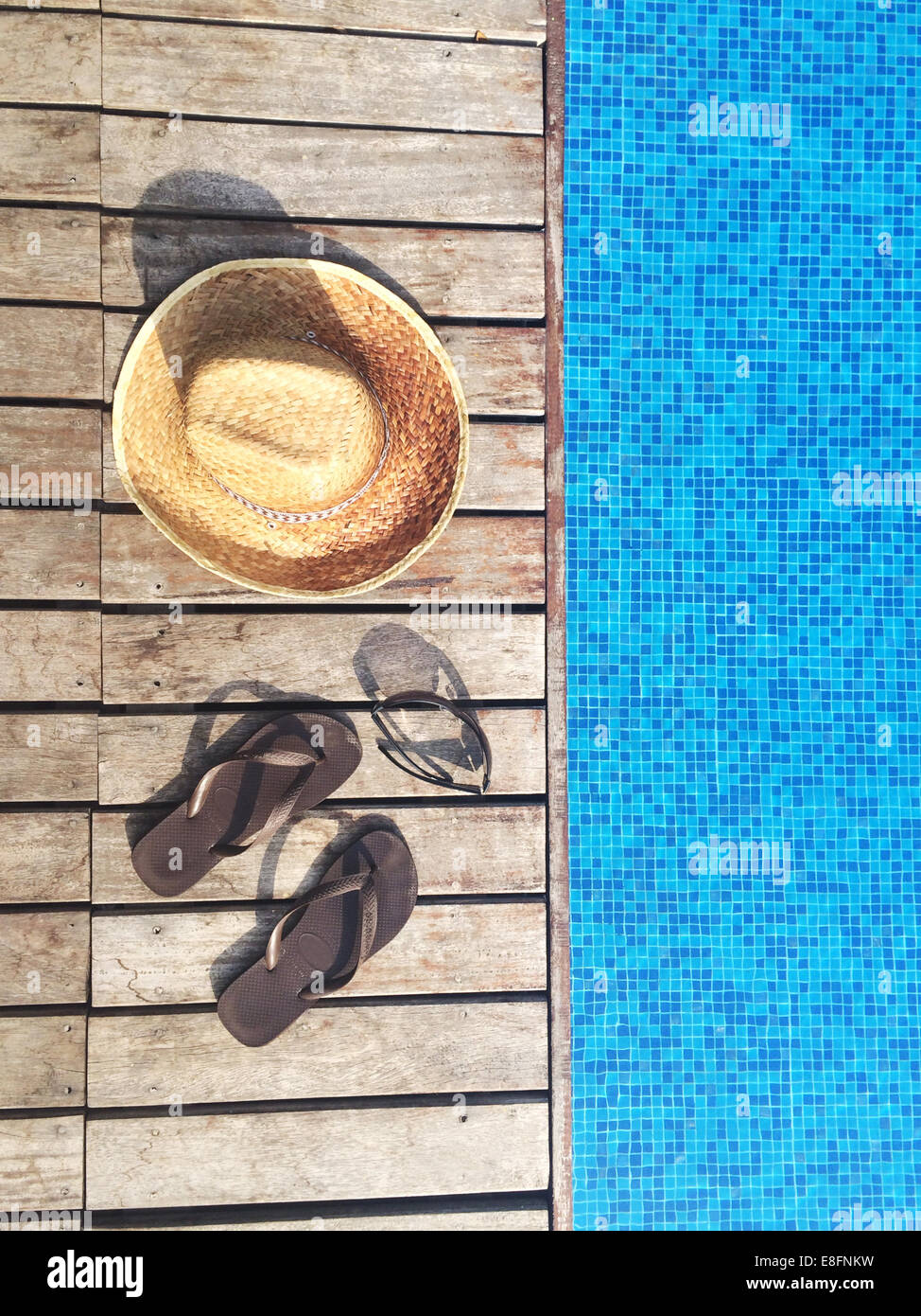 Sun hat, flip-flops and sunglasses by swimming pool Stock Photo - Alamy