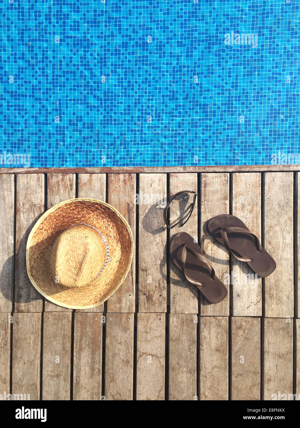 Sun hat, flip-flops and sunglasses by swimming pool Stock Photo - Alamy