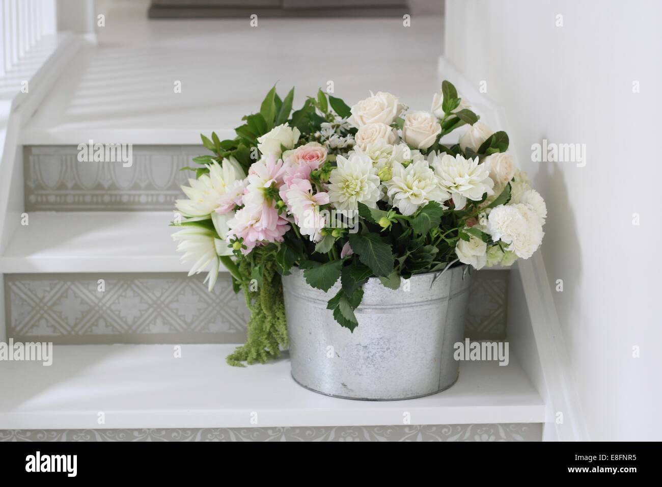 Bucket of cut flowers on steps Stock Photo Alamy