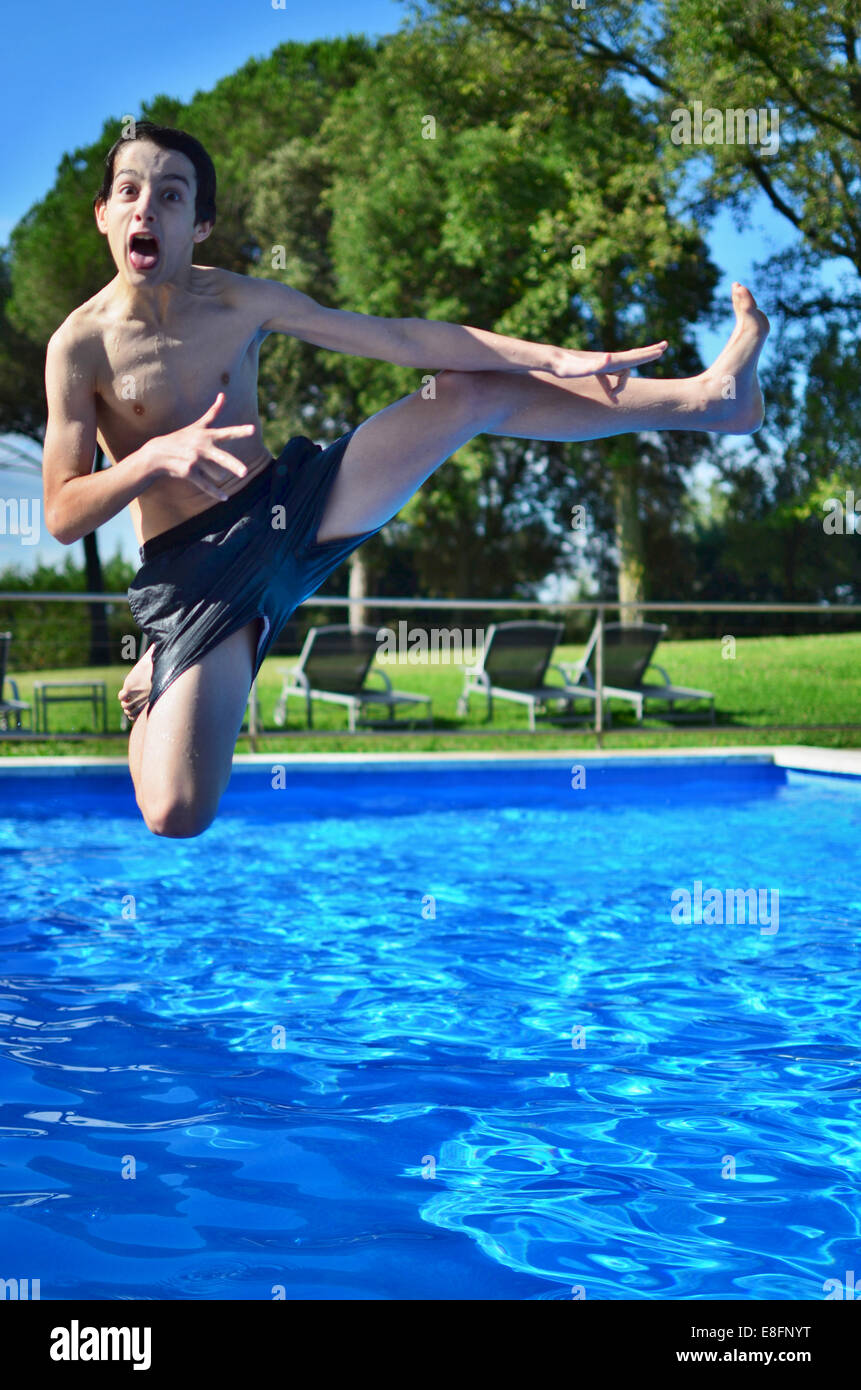 Boy jumping into swimming pool Stock Photo