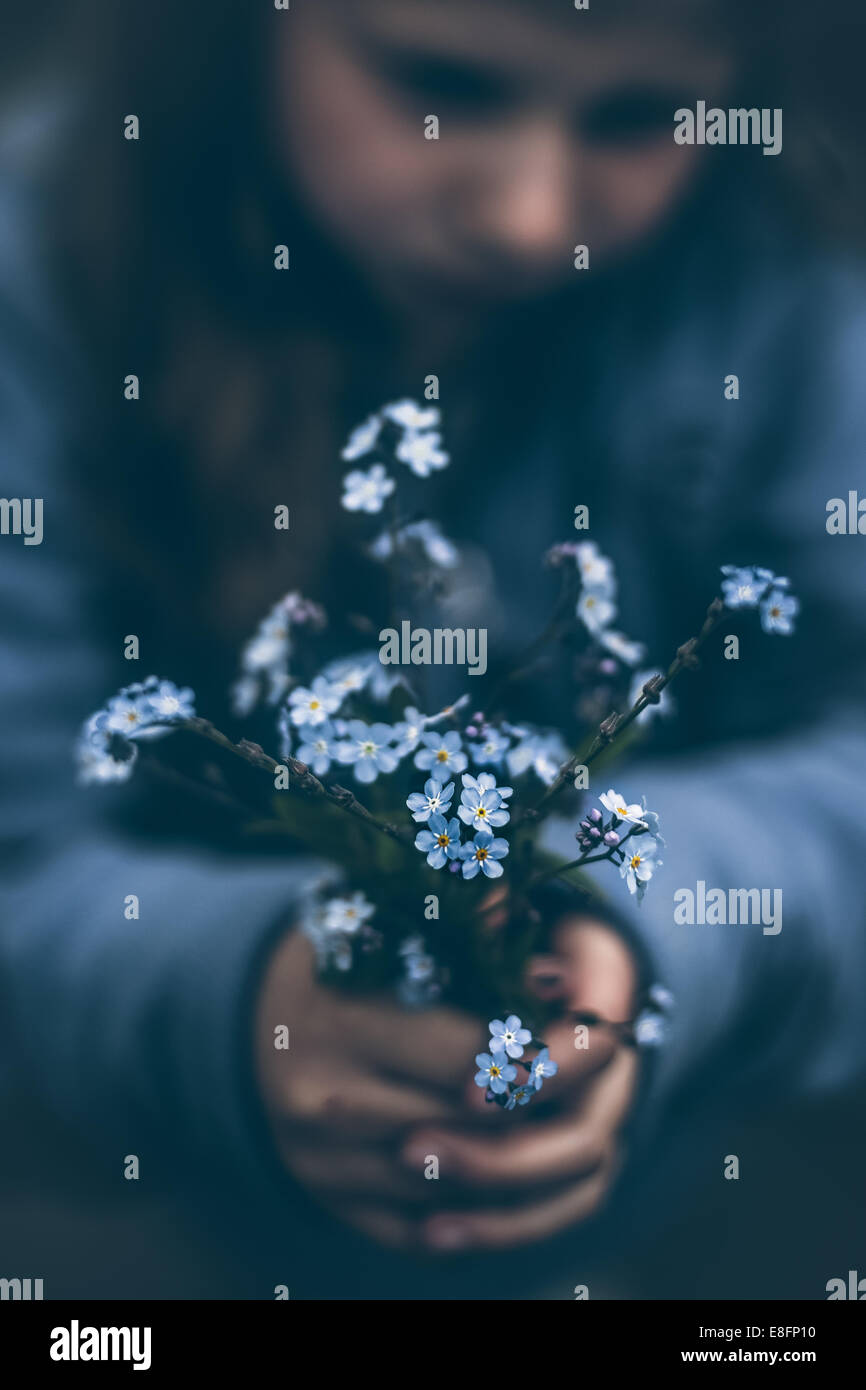 Girl holding bouquet of forget-me-not flowers Stock Photo