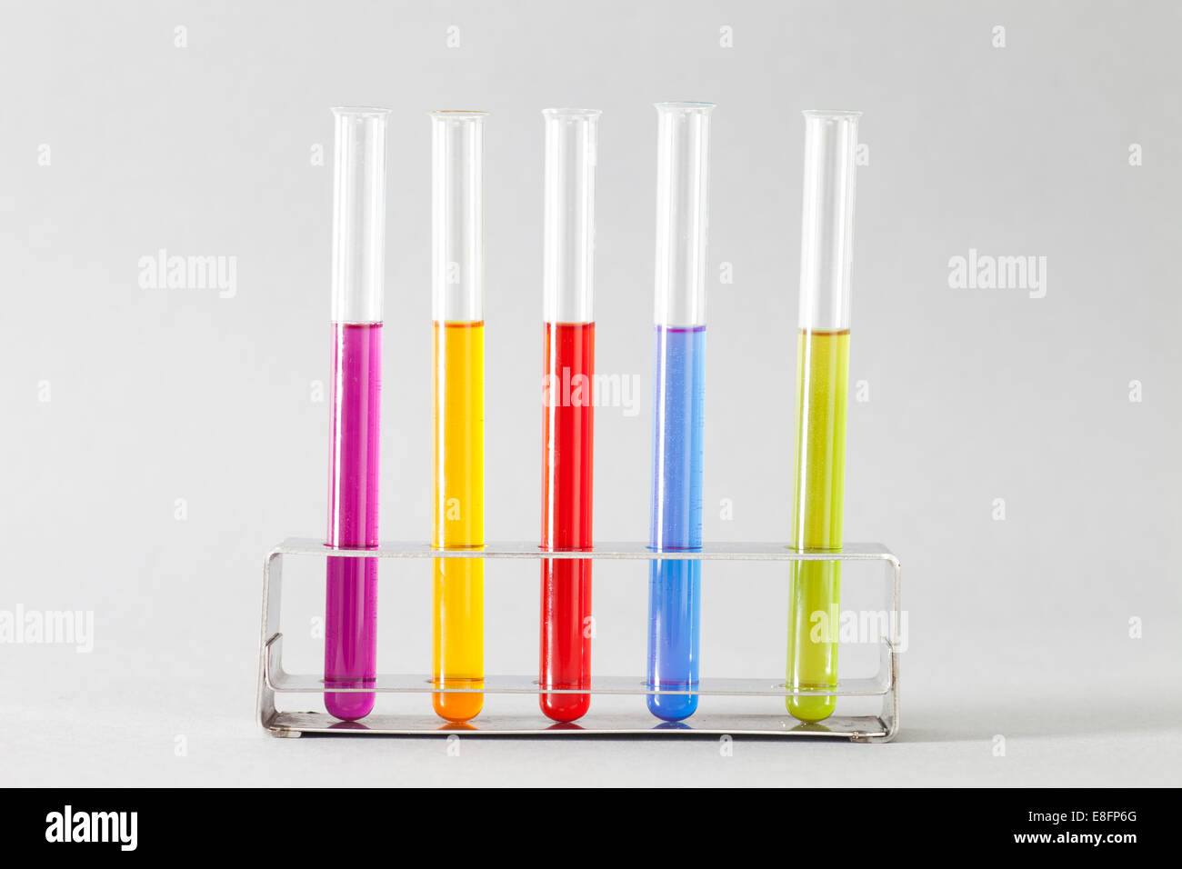 Test Tubes with multi coloured liquid in rack Stock Photo