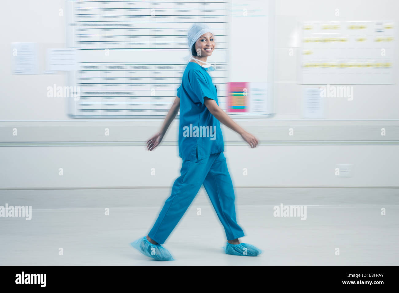 Doctor walking past schedule board in hospital Stock Photo