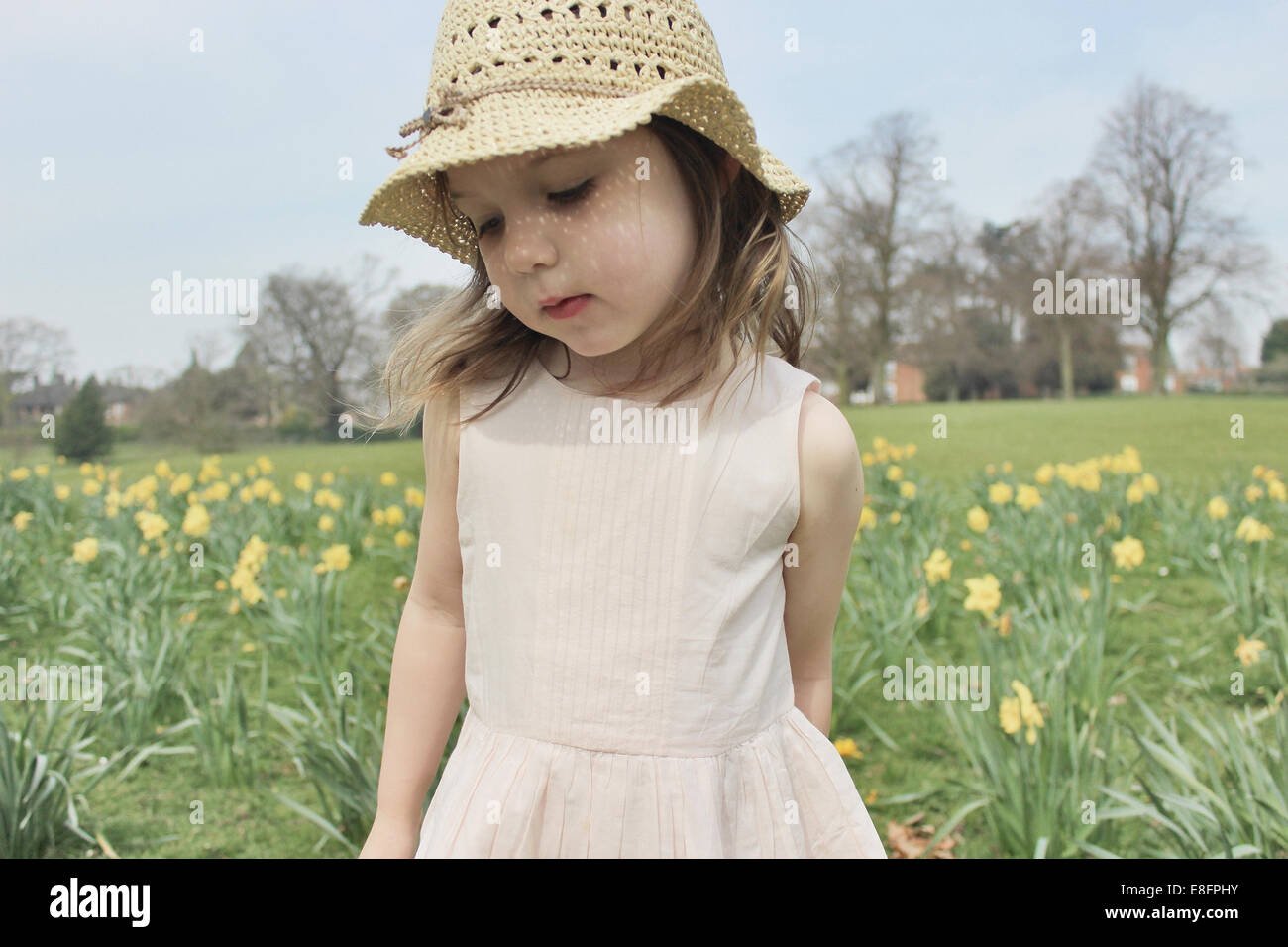 Girl wearing a straw hat standing in a field Stock Photo - Alamy