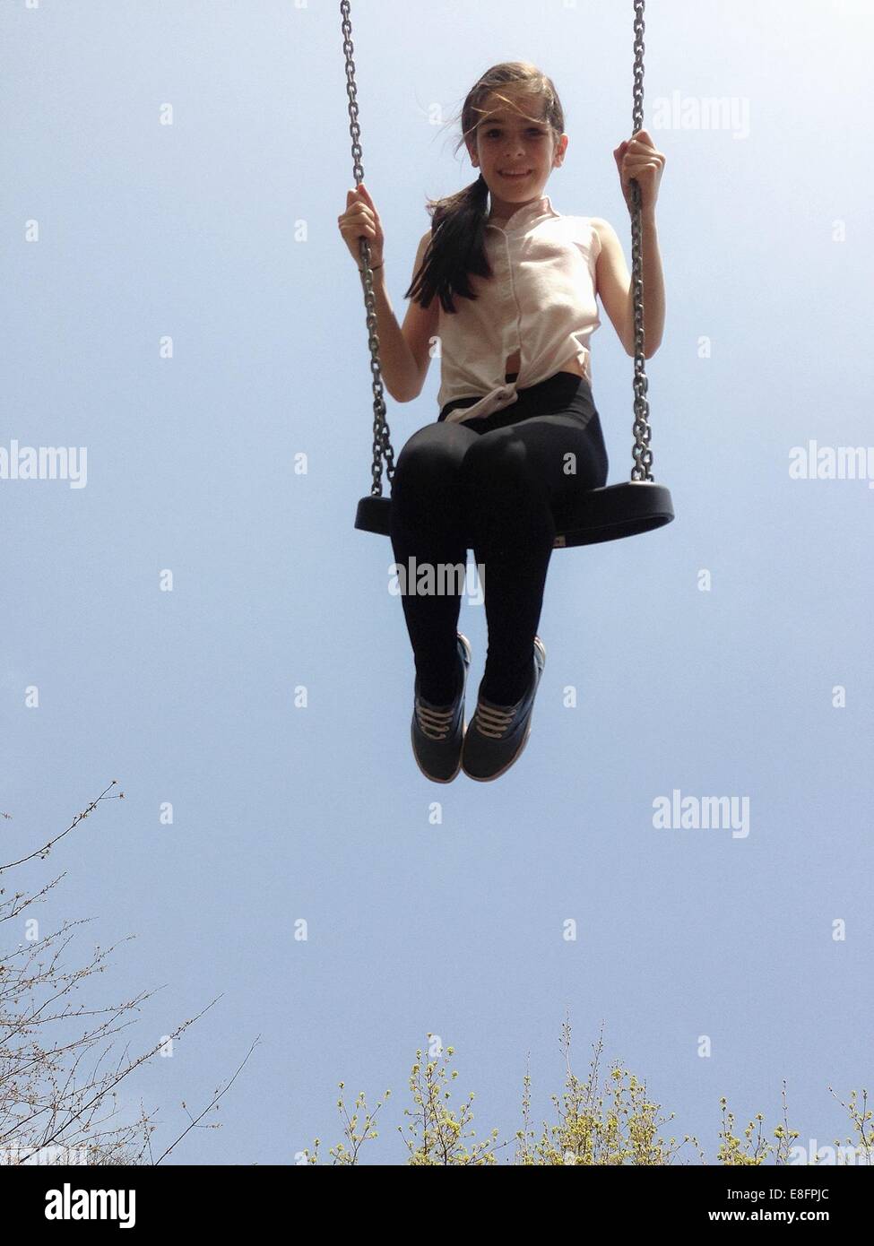 Girl sitting on a swing Stock Photo