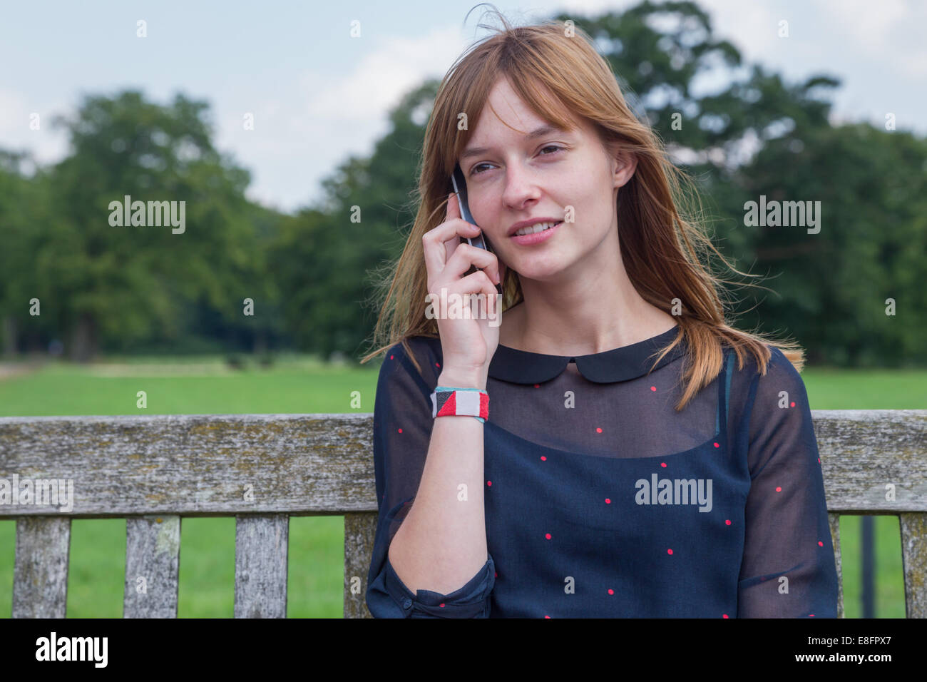 Redhead Girl phoning with mobile phone in nature Stock Photo