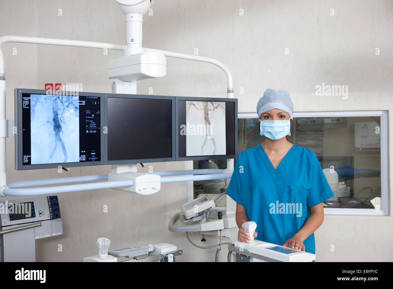 Portrait of a surgeon standing in operating theatre Stock Photo