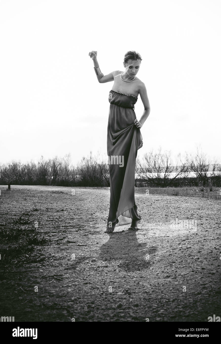 Woman wearing long dress standing in meadow Stock Photo