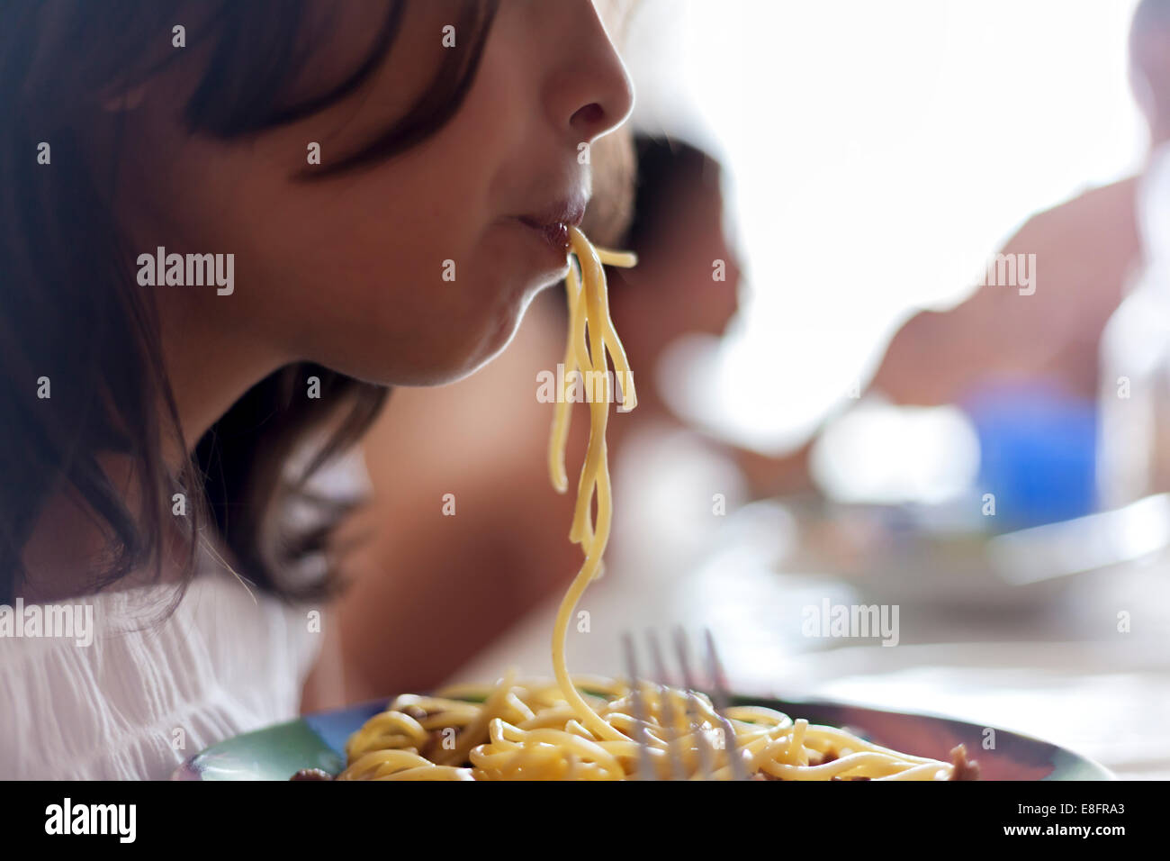 Close-up portrait of girl eating spaghetti Stock Photo