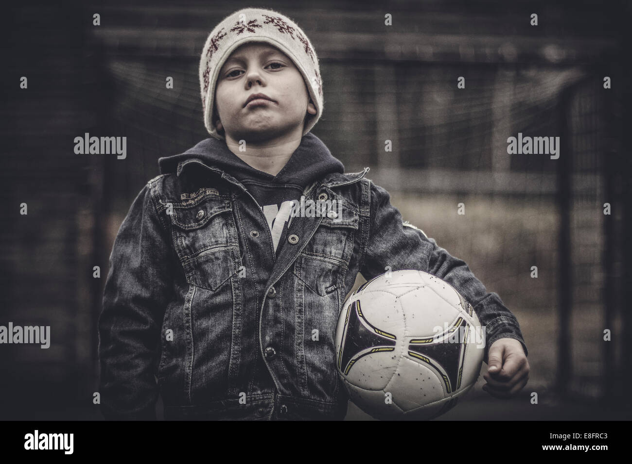 Portrait of a serious boy holding a football Stock Photo