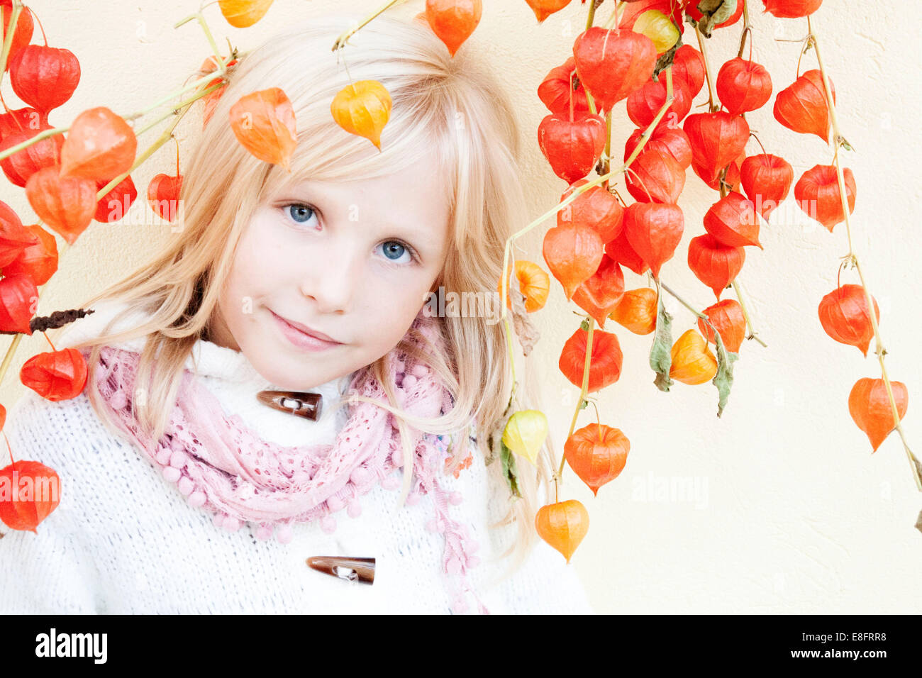 Portrait of smiling girl standing by a Chinese lantern plant Stock Photo
