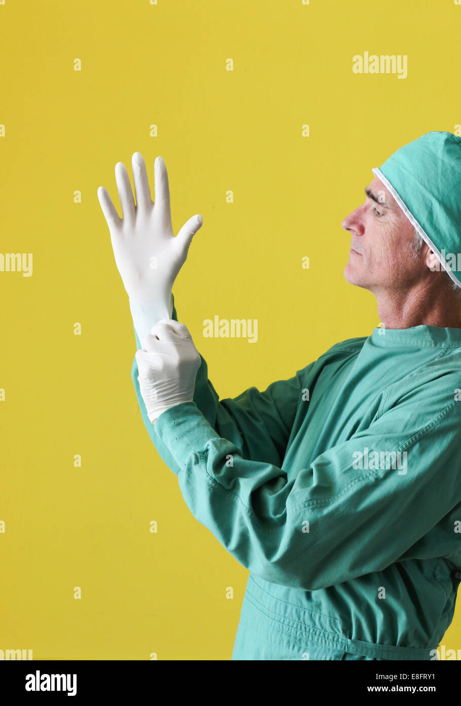 Surgeon putting on surgical gloves Stock Photo Alamy