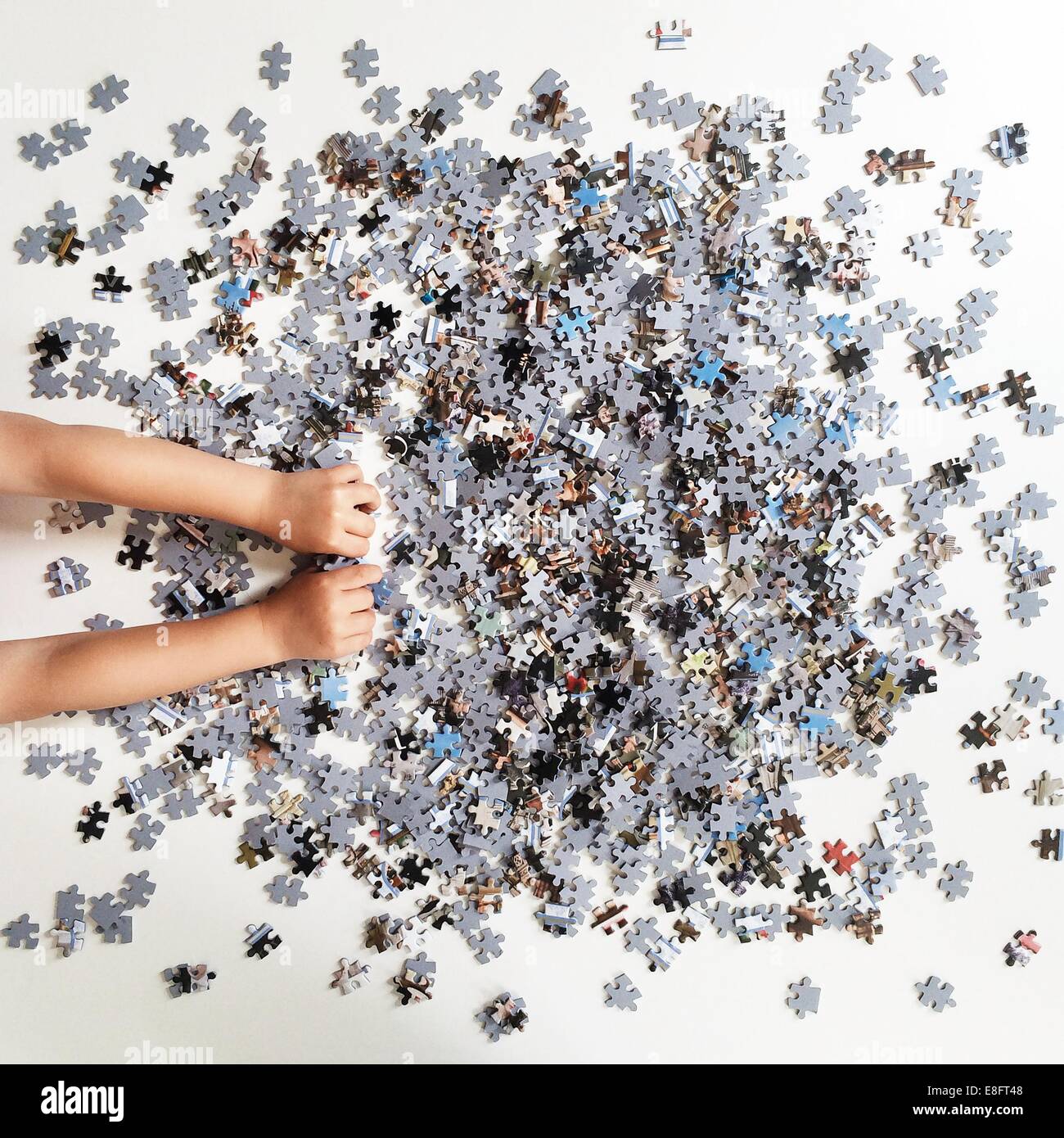 Human hands playing with jigsaw puzzle pieces Stock Photo