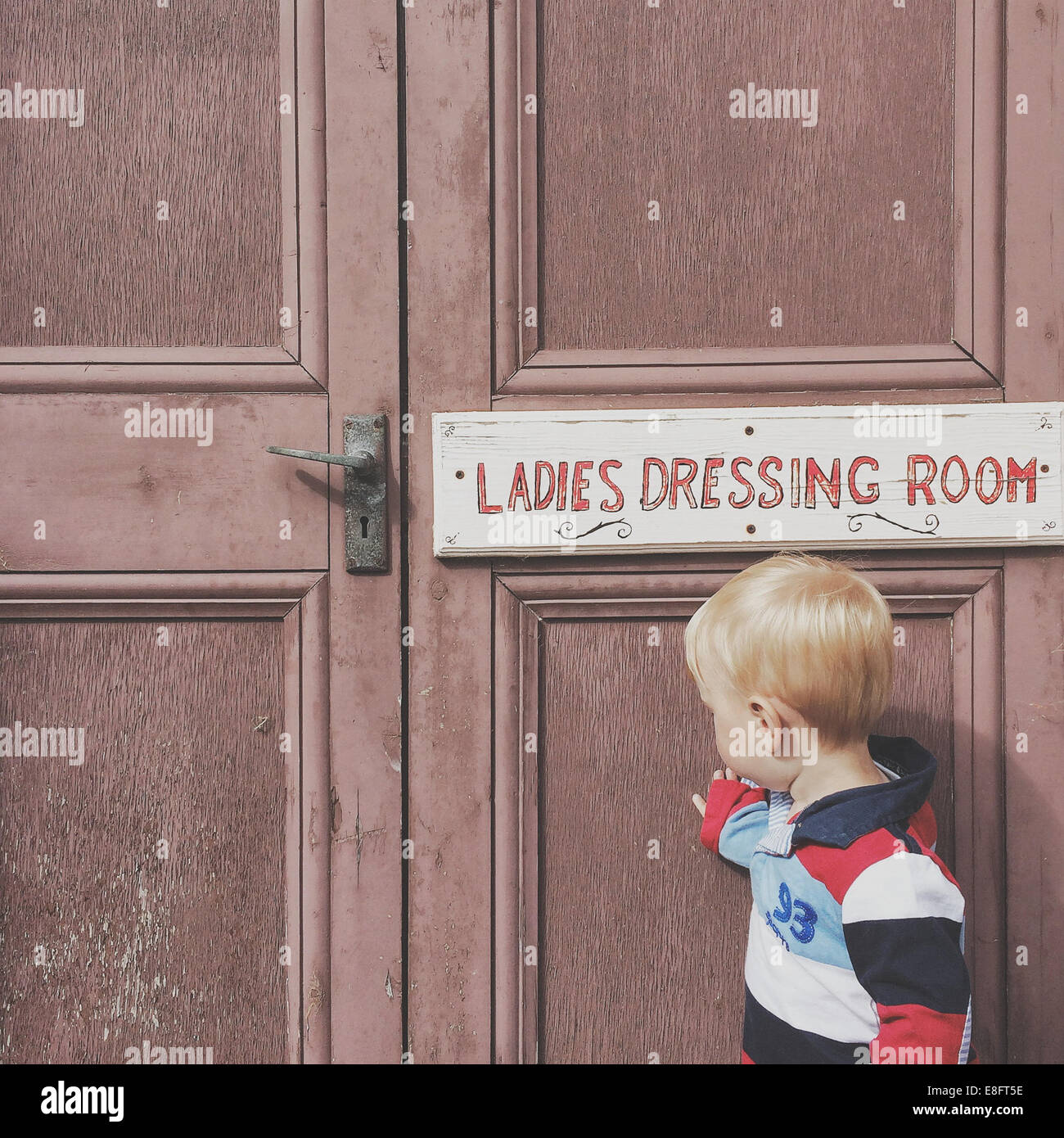 Boy standing outside ladies dressing room Stock Photo