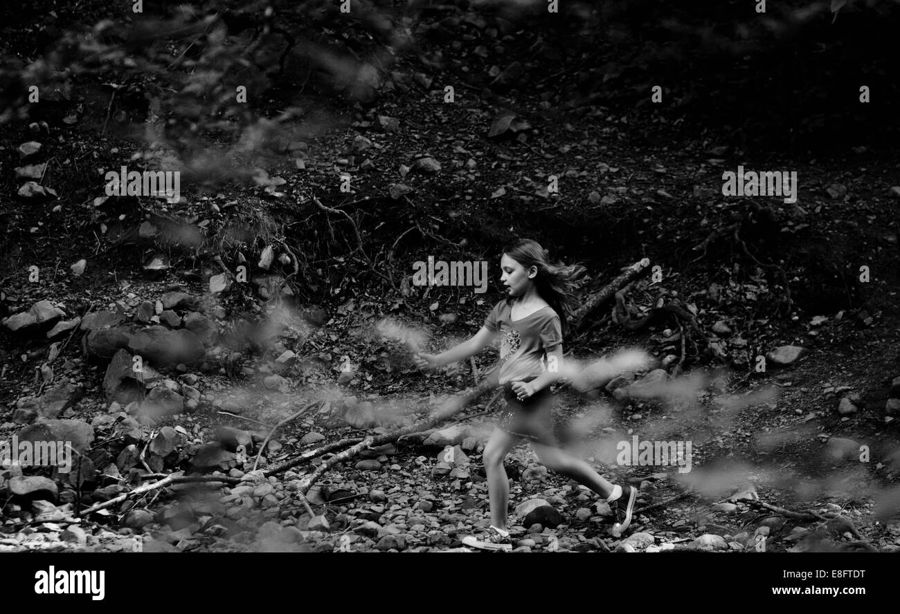 Girl running through forest Stock Photo
