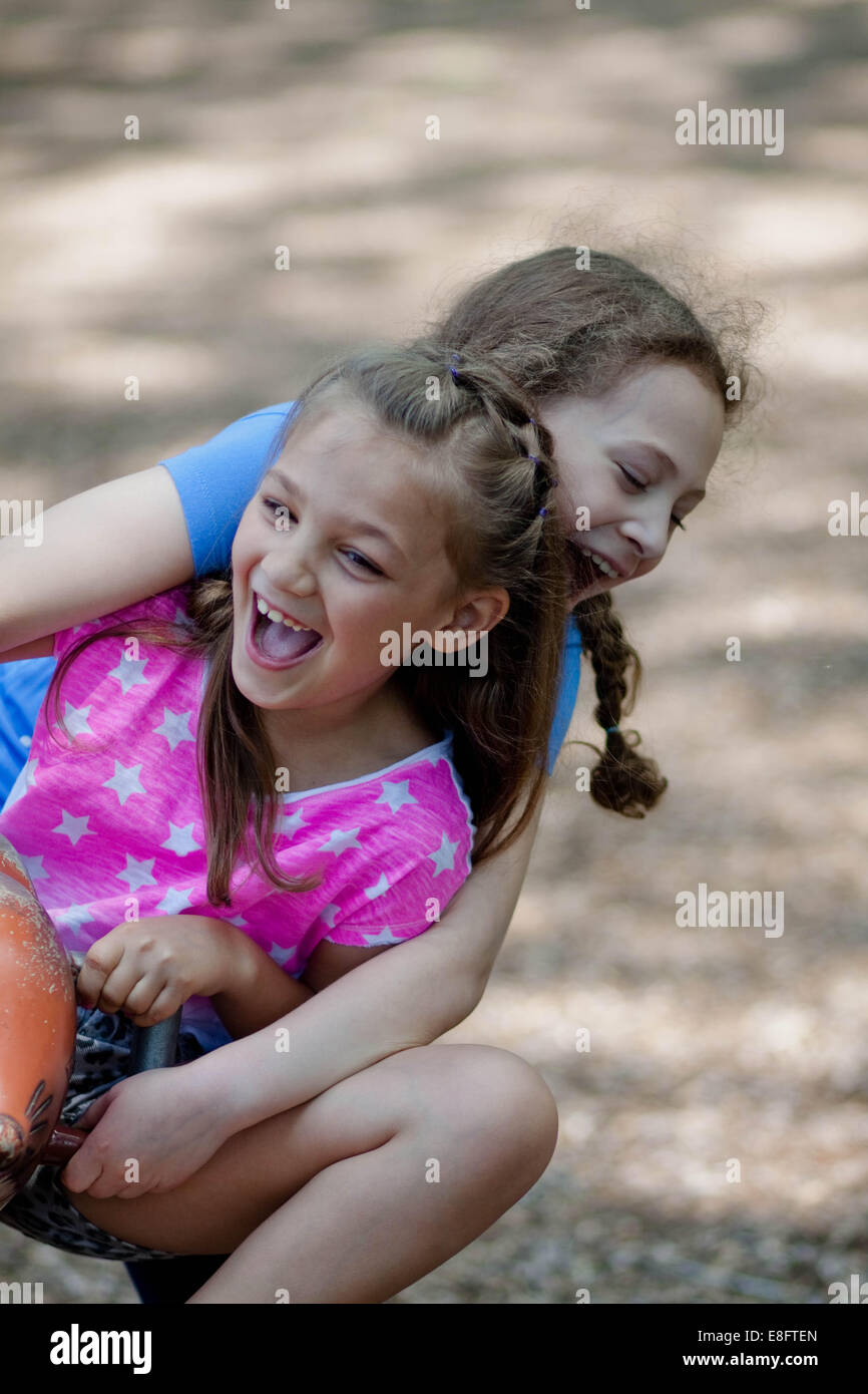 Two Girls Sitting On A Seesaw In The Playground Stock Photo - Alamy