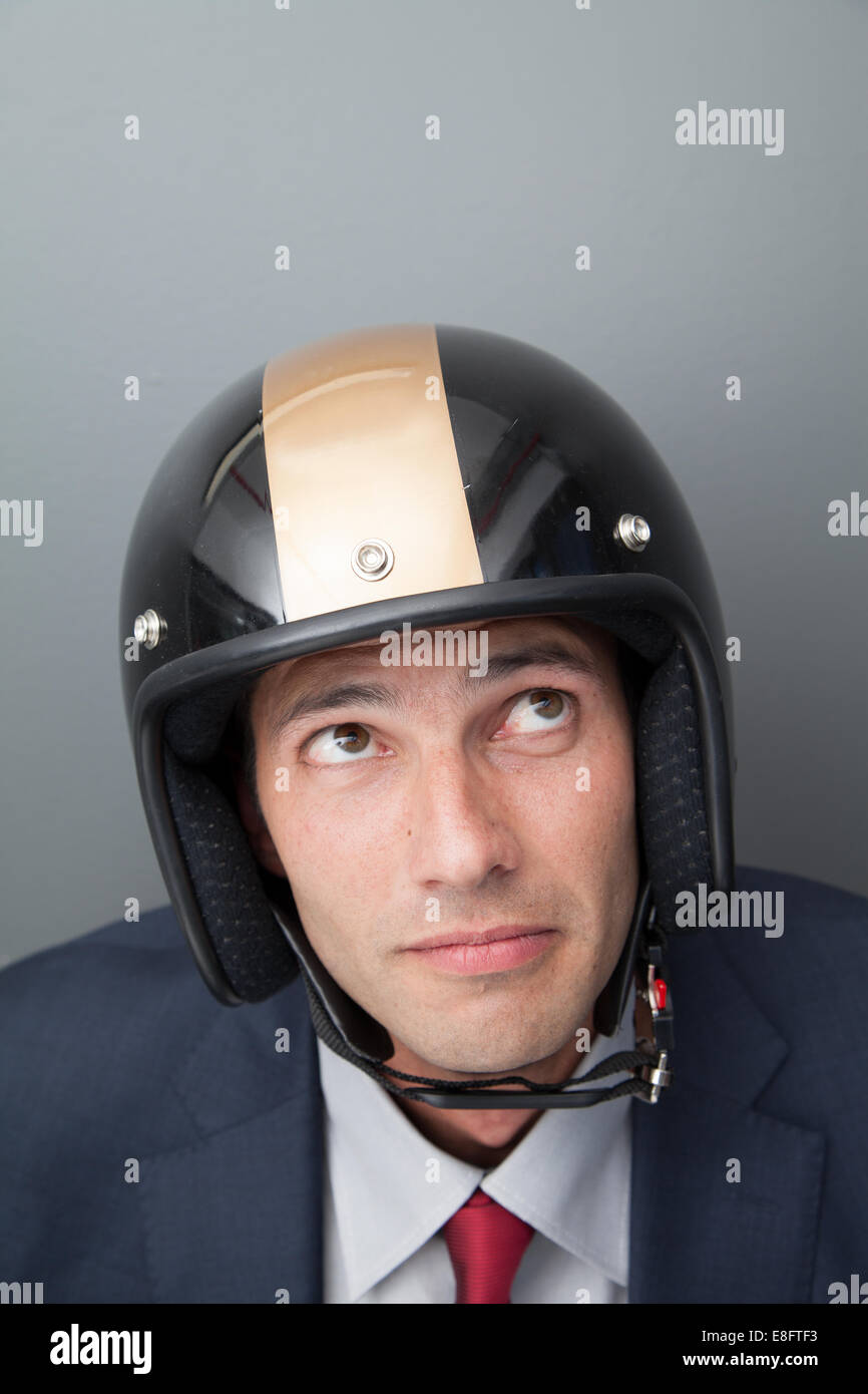Nervous businessman wearing crash helmet Stock Photo