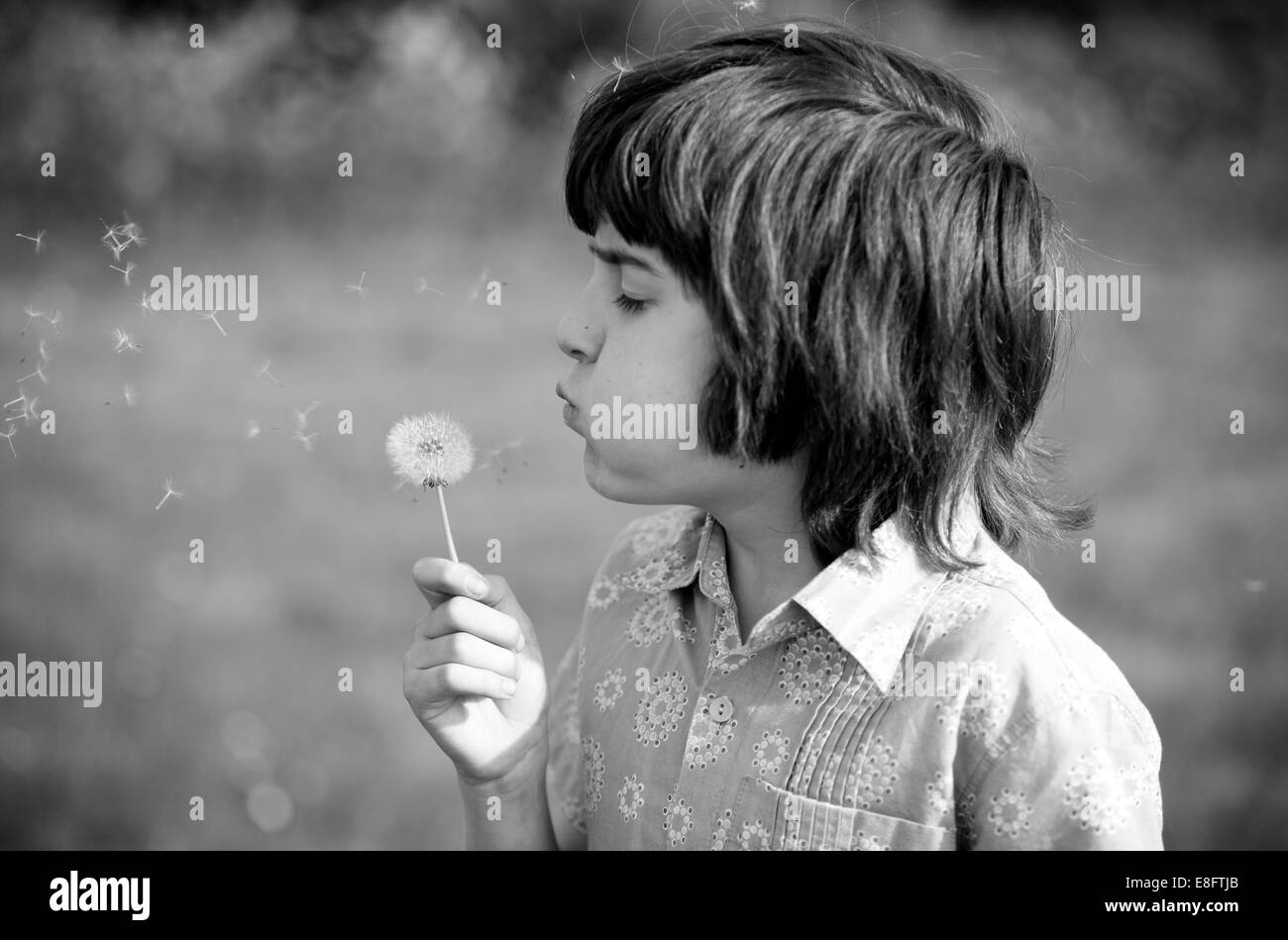 UK, England, Oxfordshire, Oxford, Young boy (10-11) blowing dandelion in field Stock Photo
