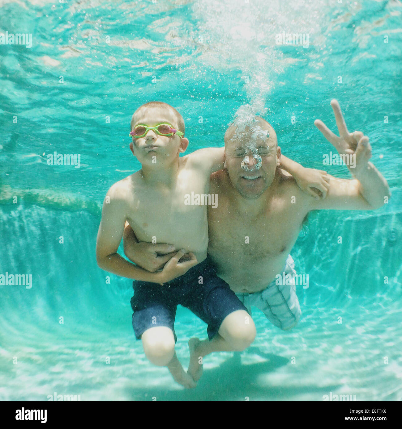 portrait of a father and son underwater in a swimming pool Stock Photo