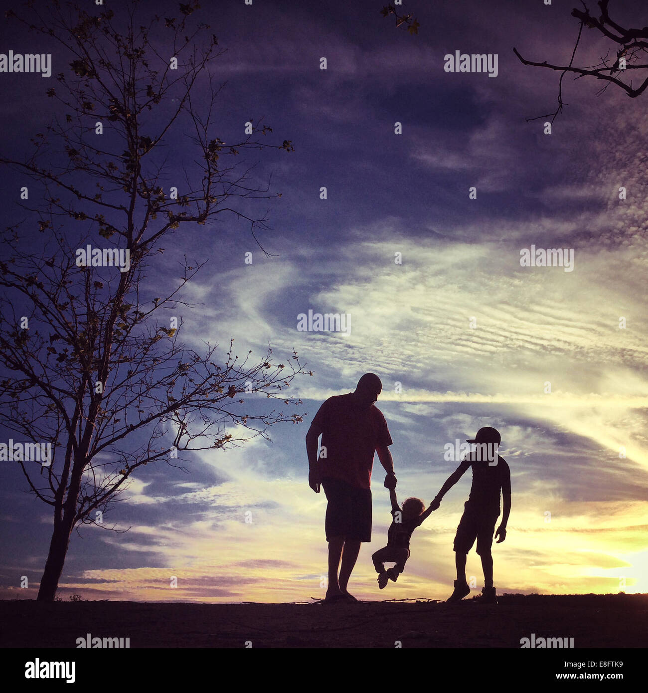 USA, California, Orange County, Father with sons at sunset Stock Photo