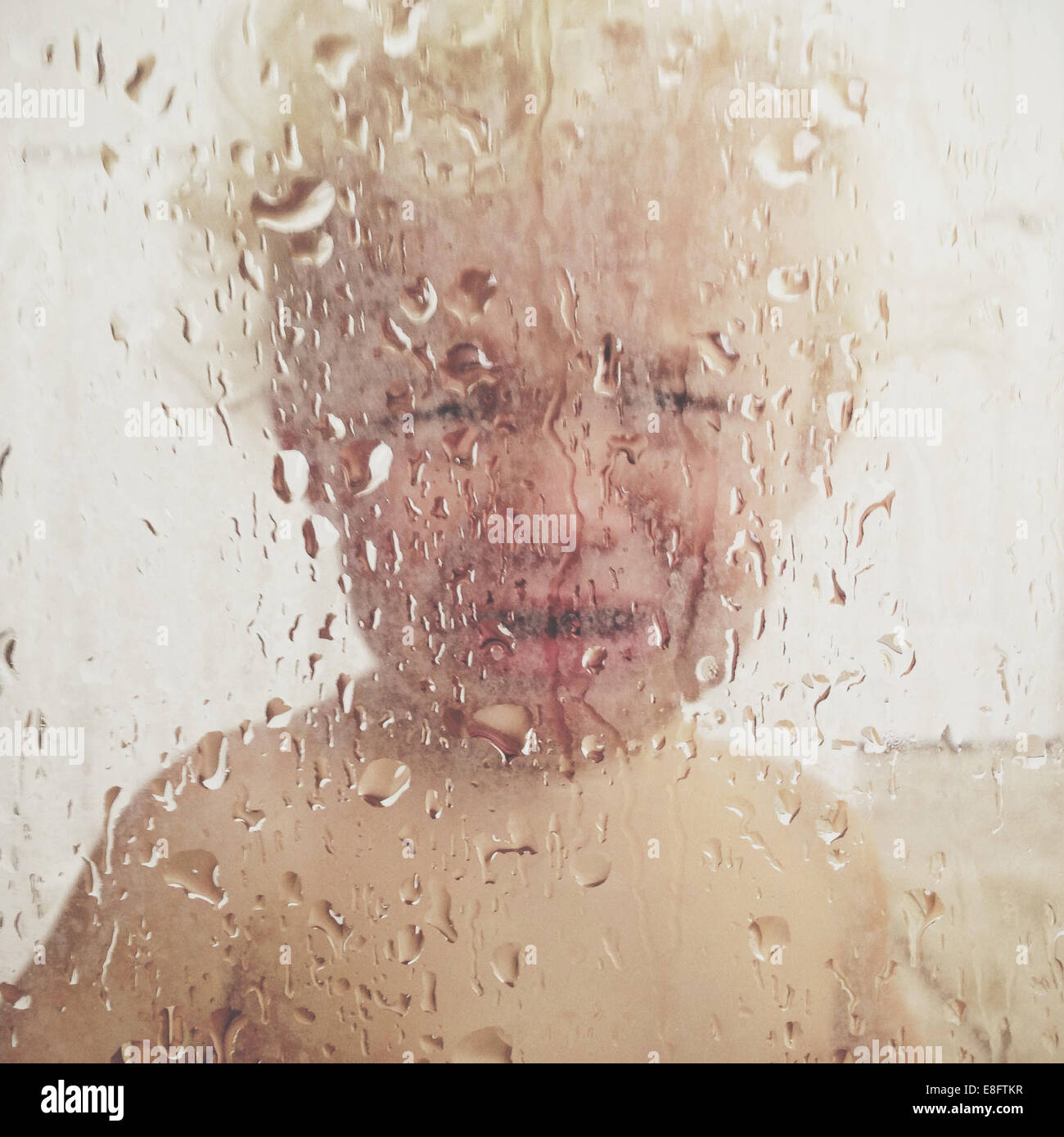 Portrait of a Boy standing in the shower crying Stock Photo