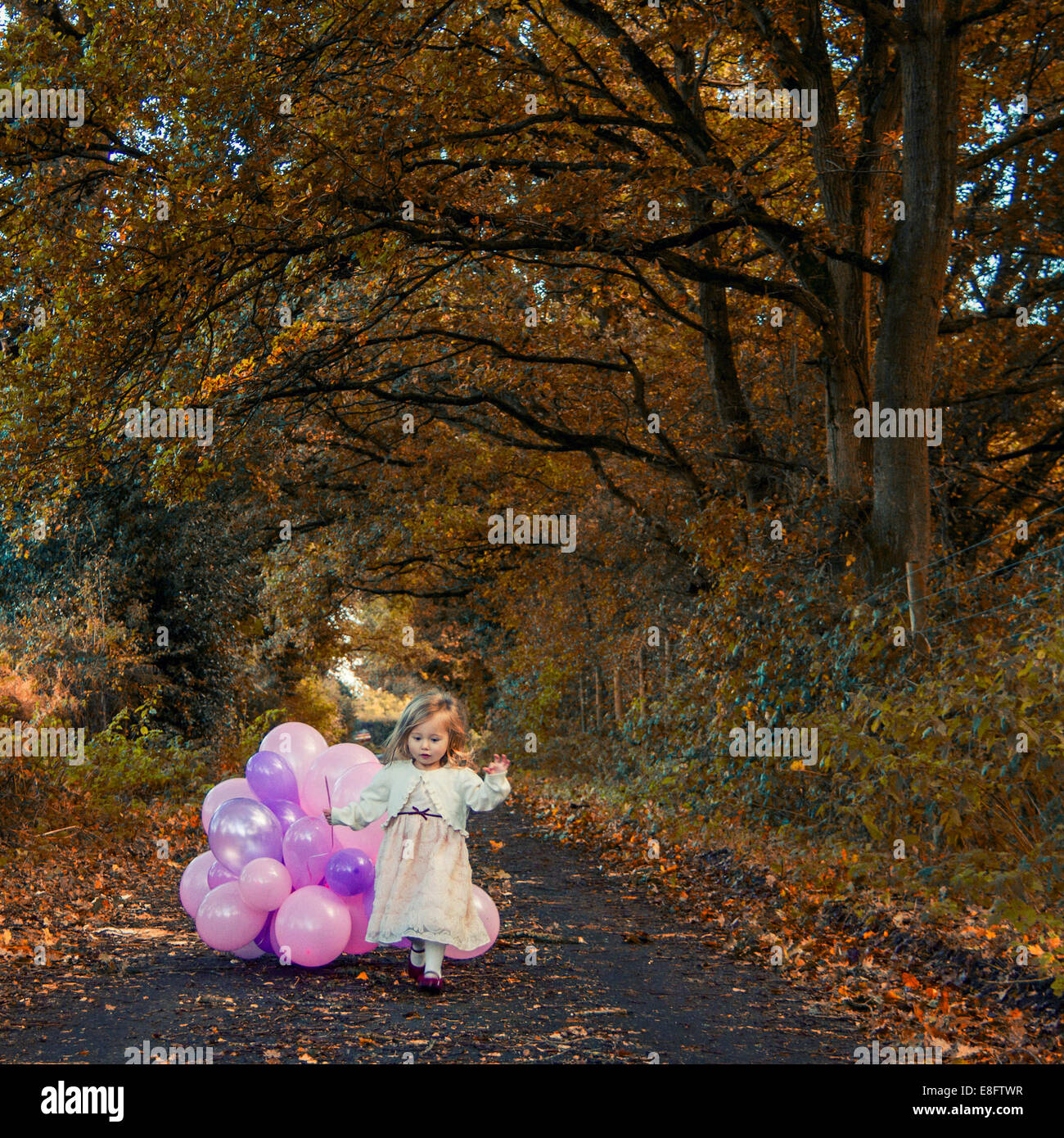 Girl walking with balloons Stock Photo - Alamy