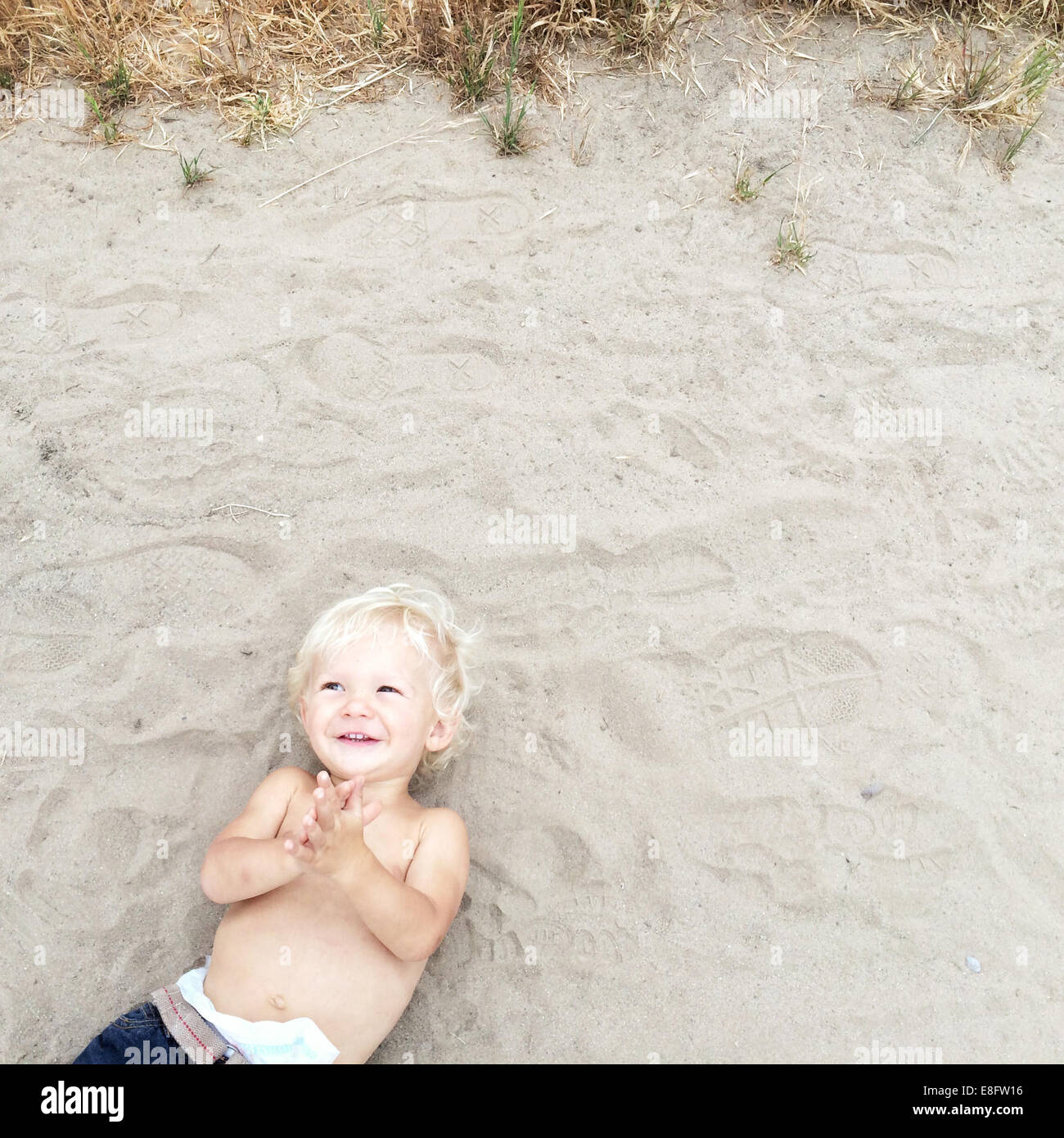 Overhead view of boy lying on beach Stock Photo