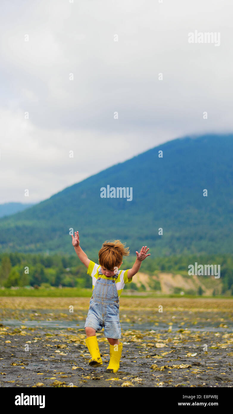 Boy running on the beach with his arms in the air, USA Stock Photo
