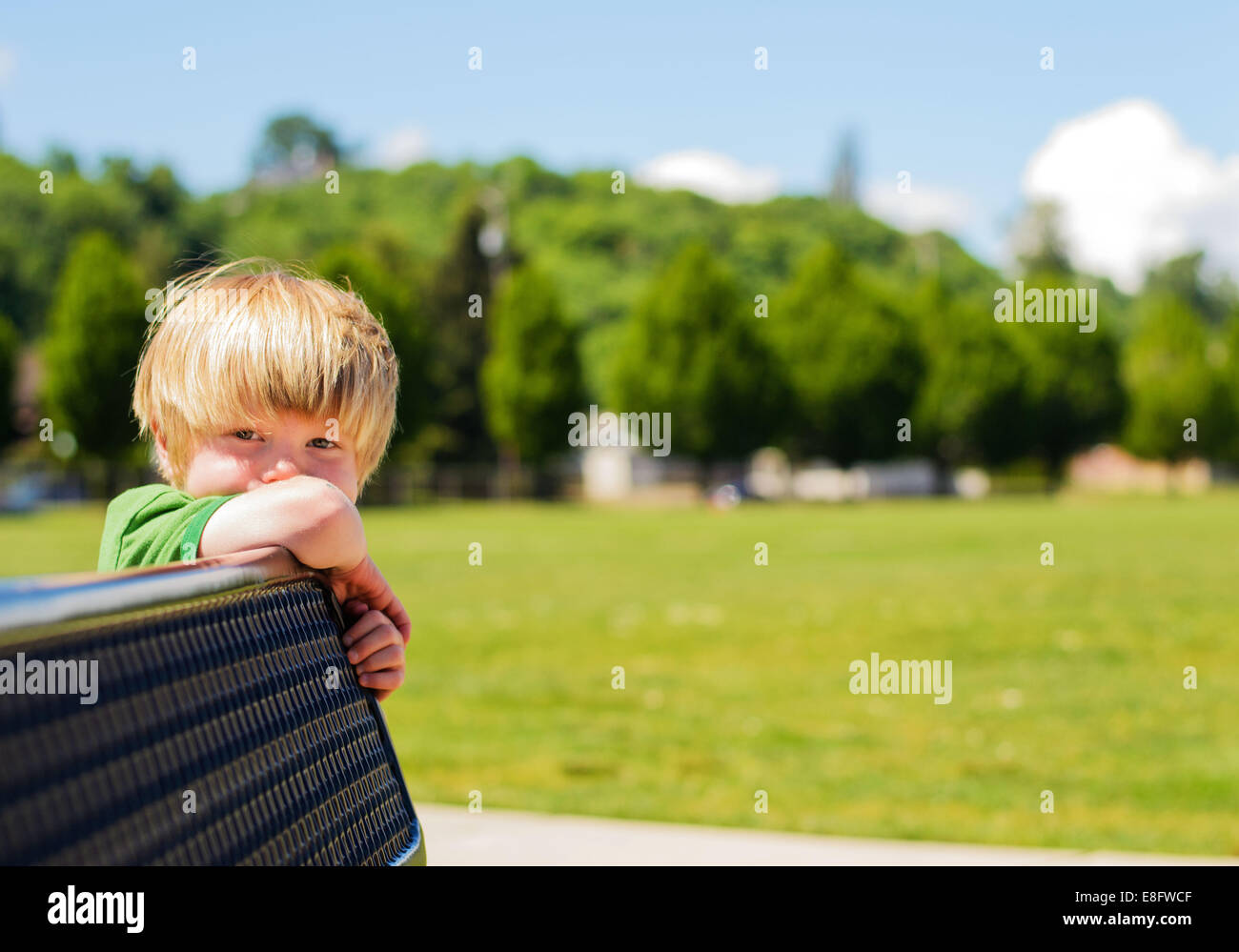 Boy leaning on bench (4-5 years) Stock Photo