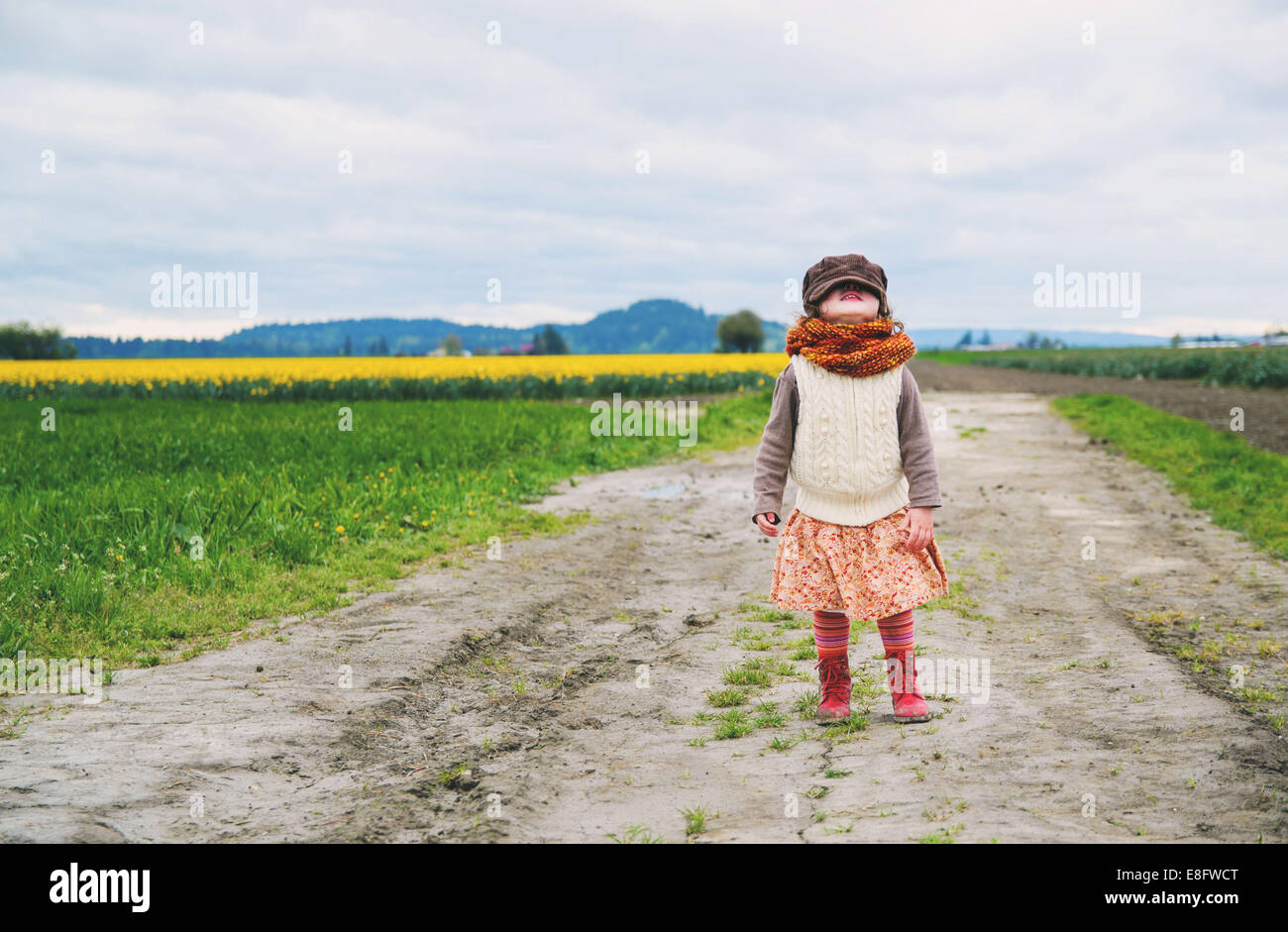 Girl standing in a tulip field looking up Stock Photo