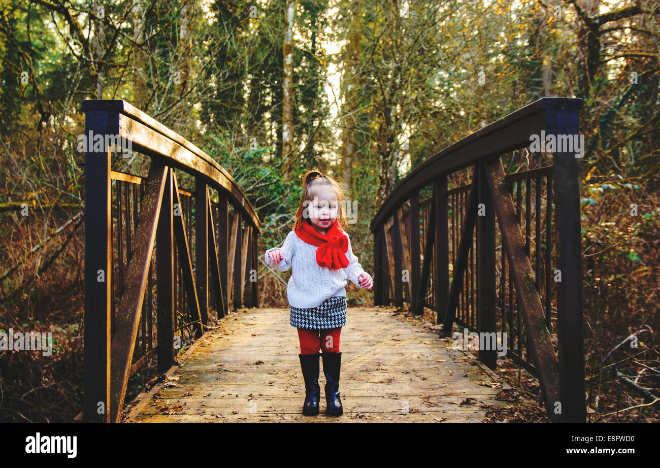 Girl standing on a bridge in the forest Stock Photo