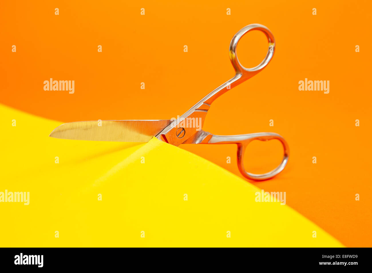 Scissors Cutting Yellow Paper Stock Photo