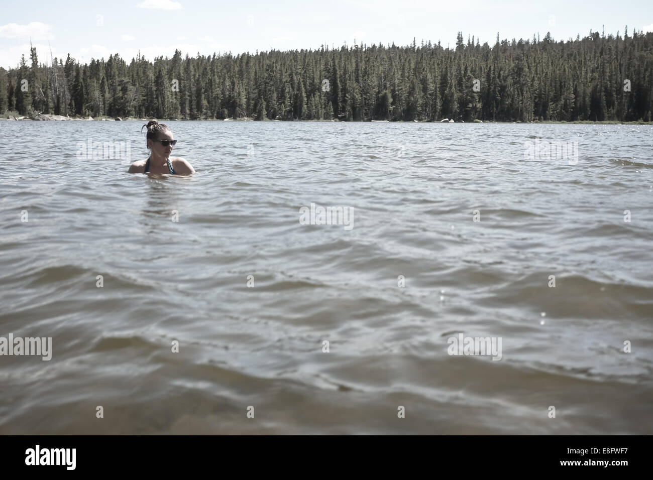 USA, Wyoming, Woman swimming in mountain lake Stock Photo