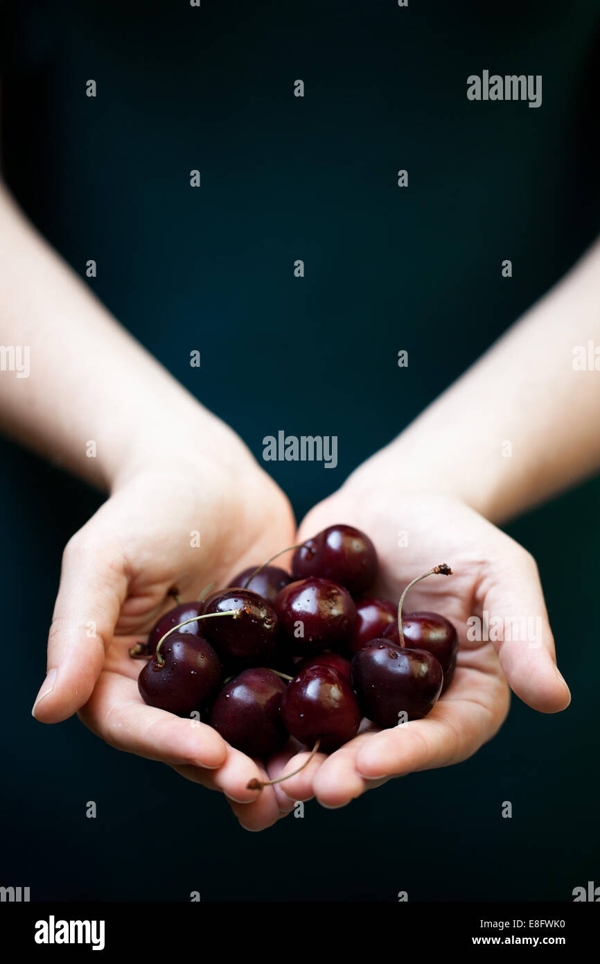 Woman holding a handful of cherries Stock Photo