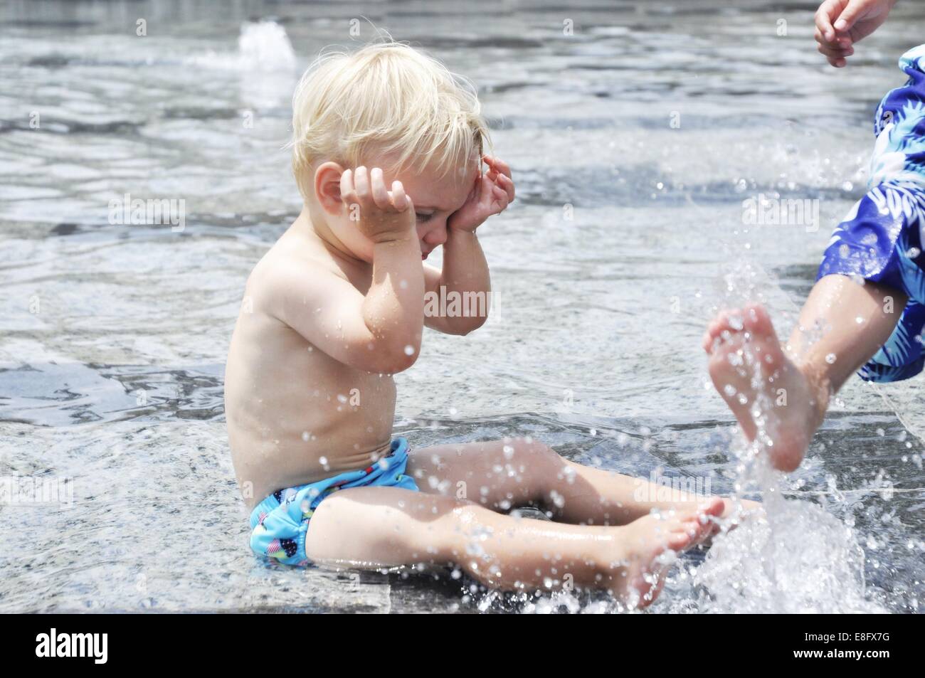Boys playing in water fountain Stock Photo