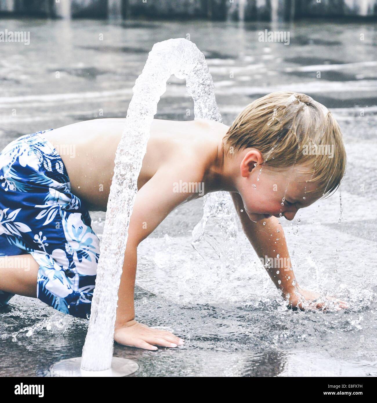 Boy playing in water fountain Stock Photo