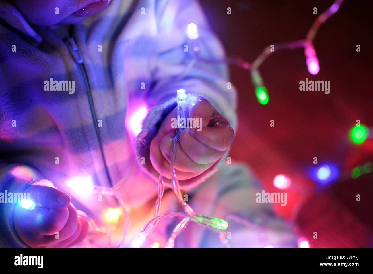 Boy playing with fairy lights Stock Photo