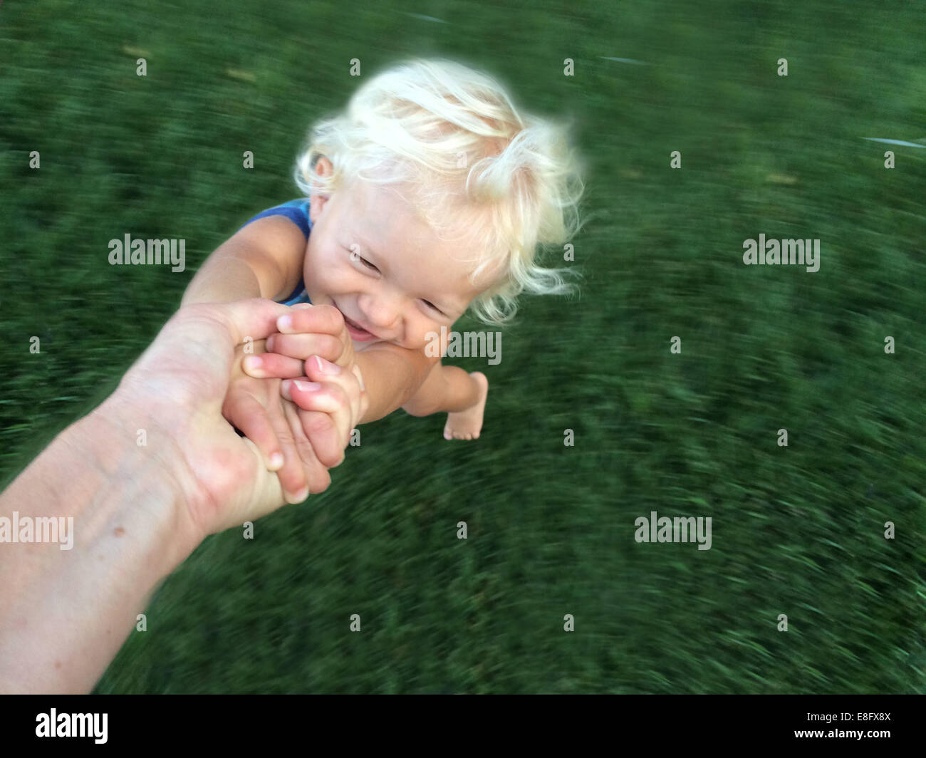 Person's hand spinning a toddler around Stock Photo Alamy