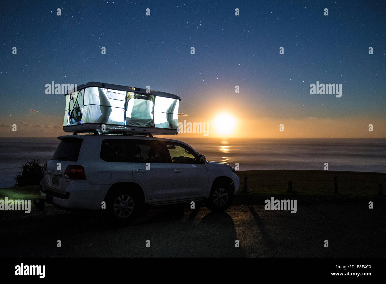 Sleeping tent on top of car at sunset Stock Photo