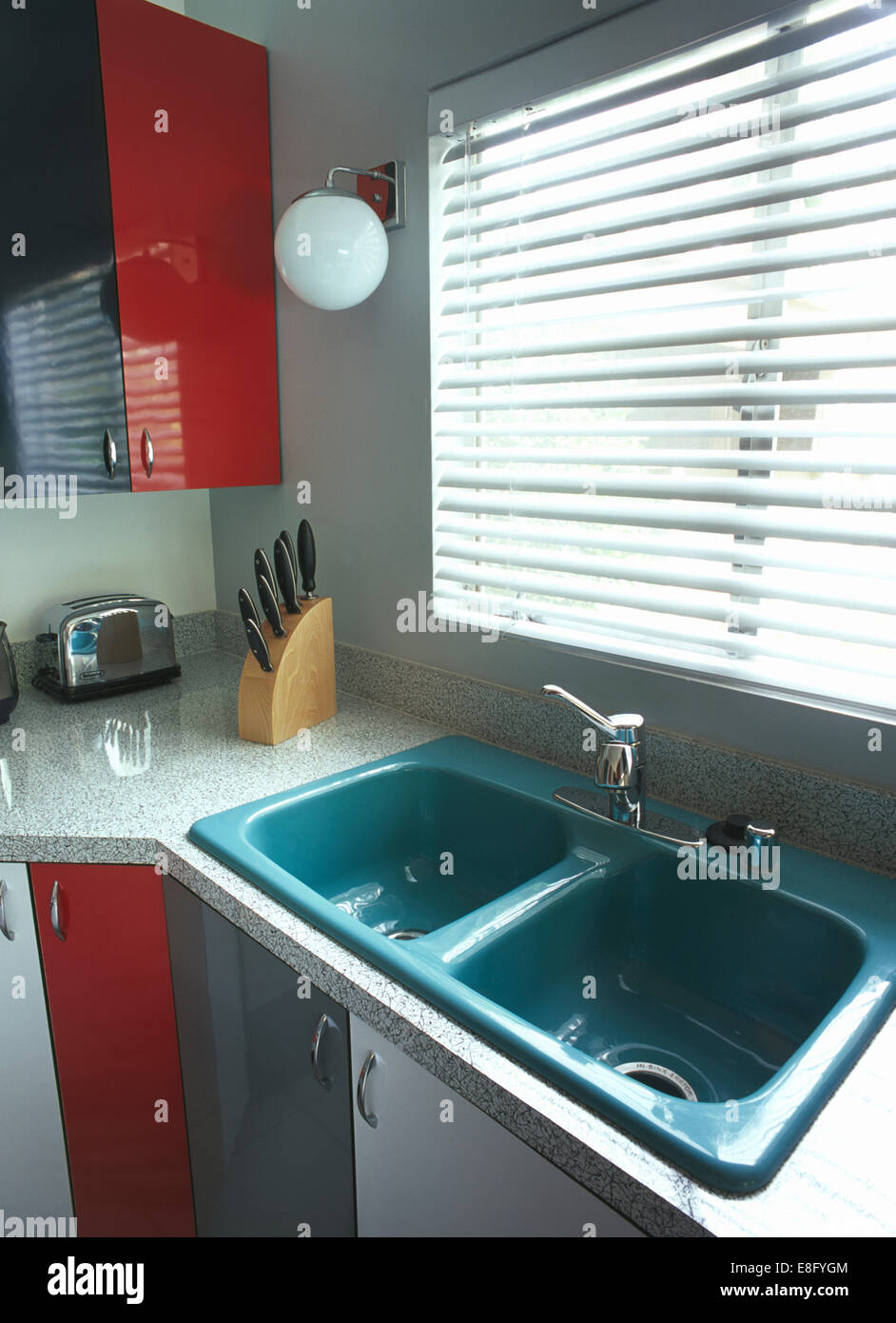 Venetian blind above blue double sinks in modern kitchen Stock Photo