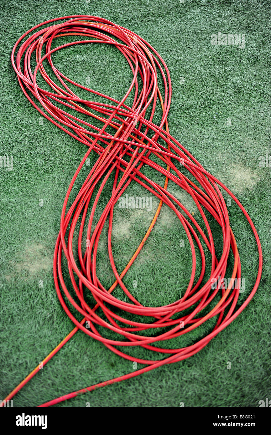 Television red cable coiled on artificial turf Stock Photo
