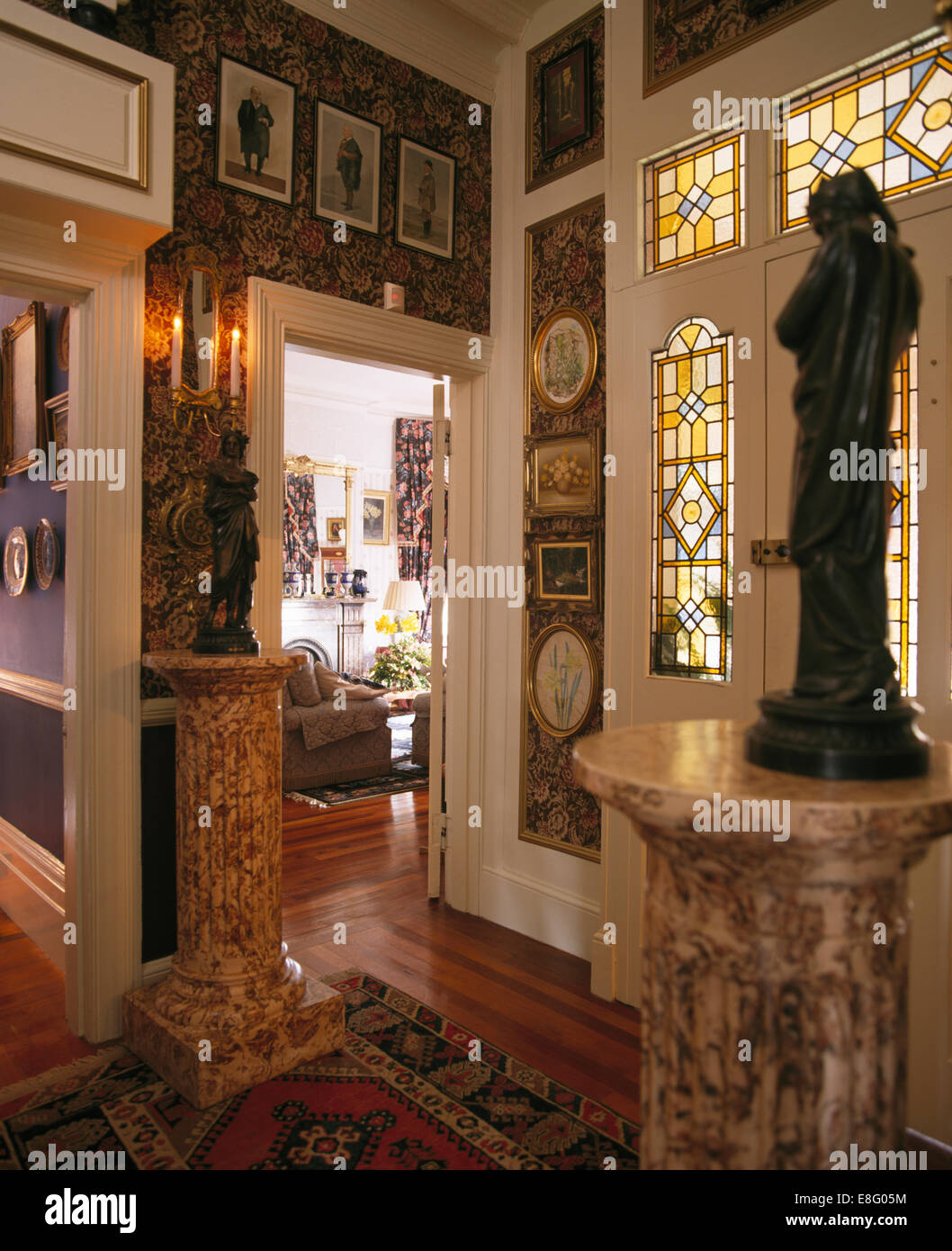 Statues on marble plinths in eighties Edwardian style hall with stained