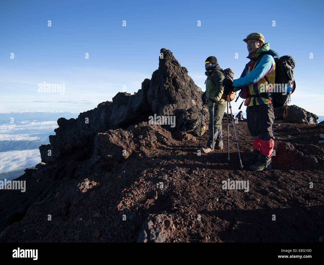 Climbing Mt. Fuji, JAPAN - Japanese Hikers at the summit at dawn Stock Photo
