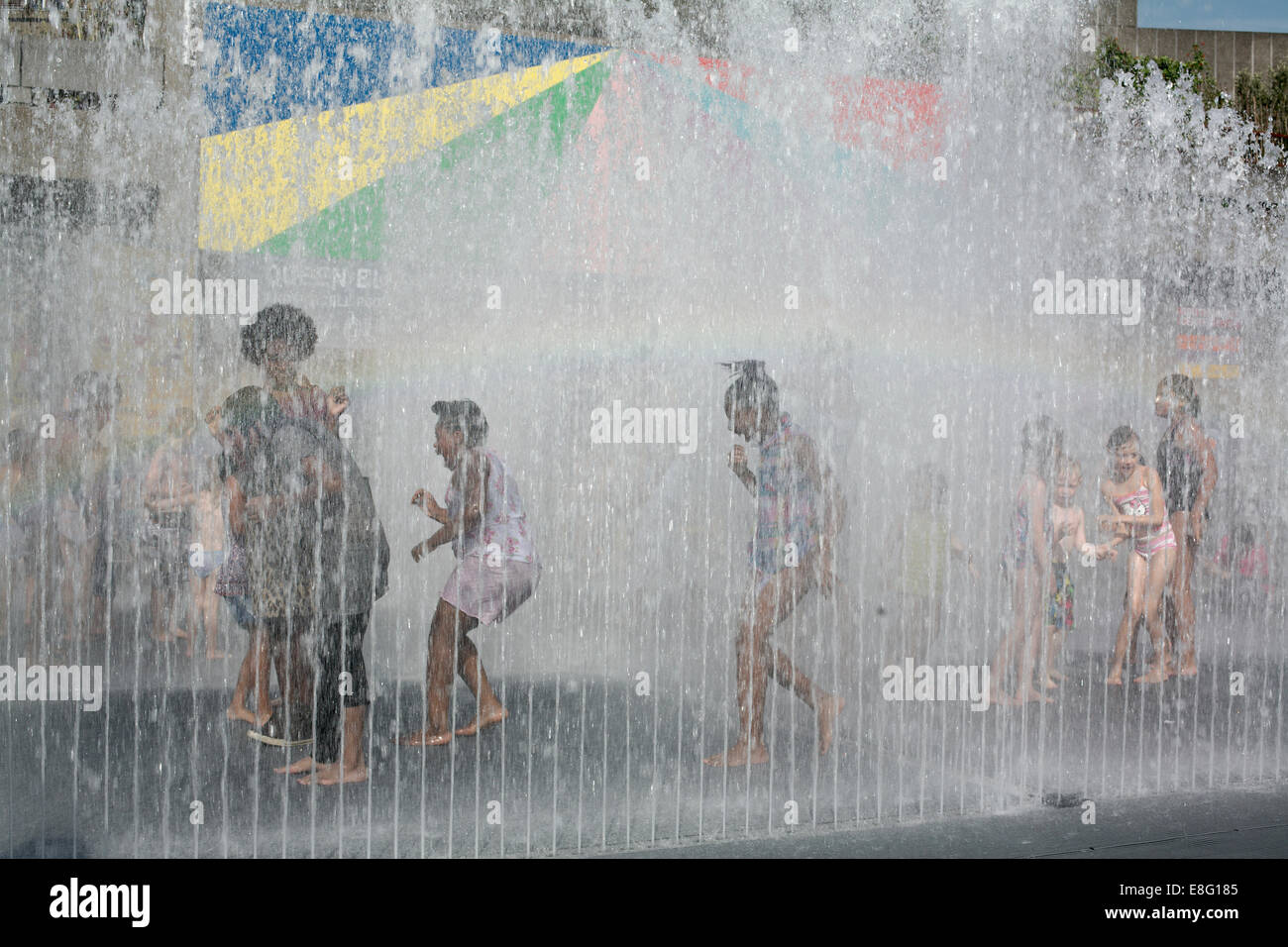 Children playing and getting wet seen through the fountain on South Bank London Stock Photo