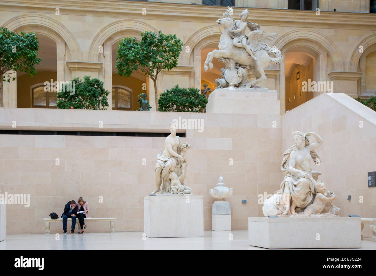 Man and woman on bench in the Richelieu section of Musee du Louvre, Paris, France Stock Photo