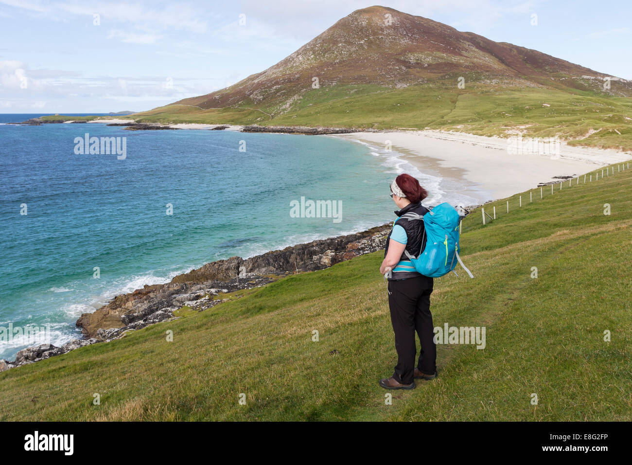 Walker Enjoying the View Over the Beach of Traigh na Cleabhaig to the Hill of Ceapabhal, South Harris Hebrides Scotland Stock Photo