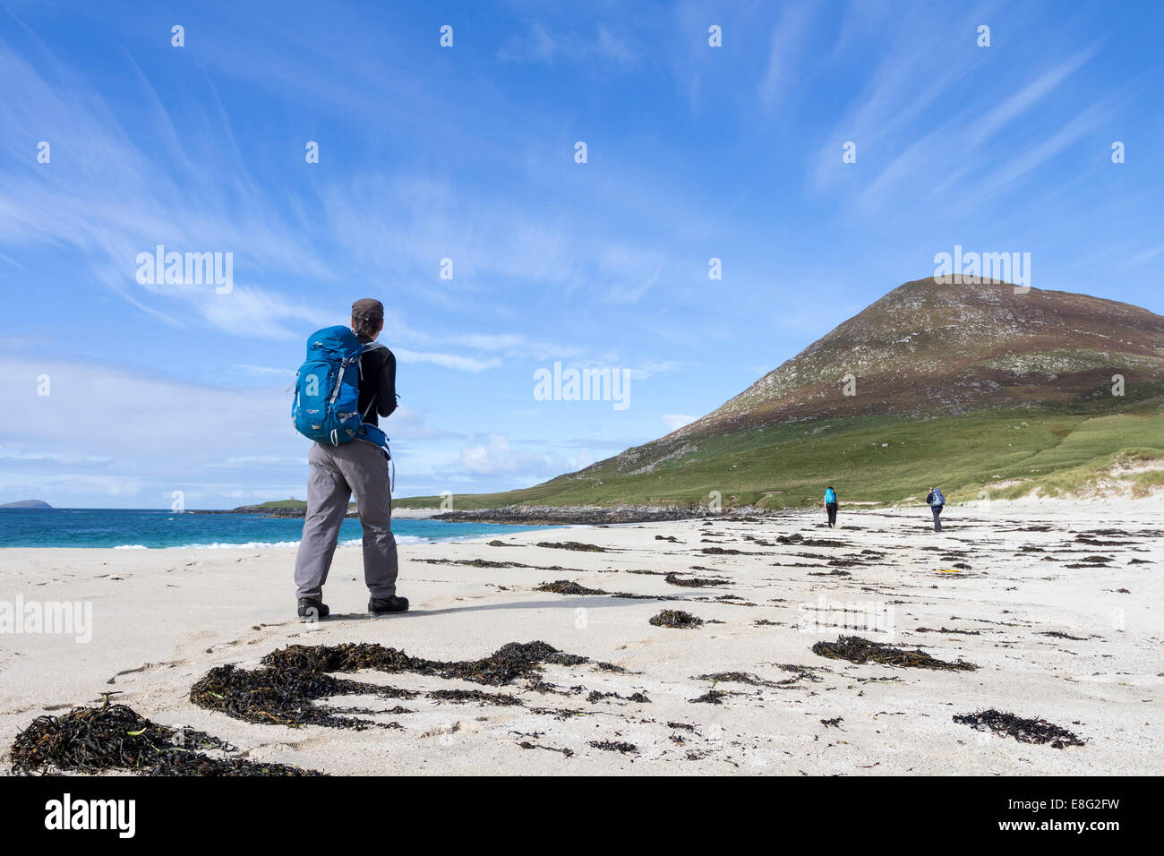 Walkers on Traigh na Cleabhaig With the Hill of Ceapabhal Ahead, South Harris Hebrides Scotland Stock Photo