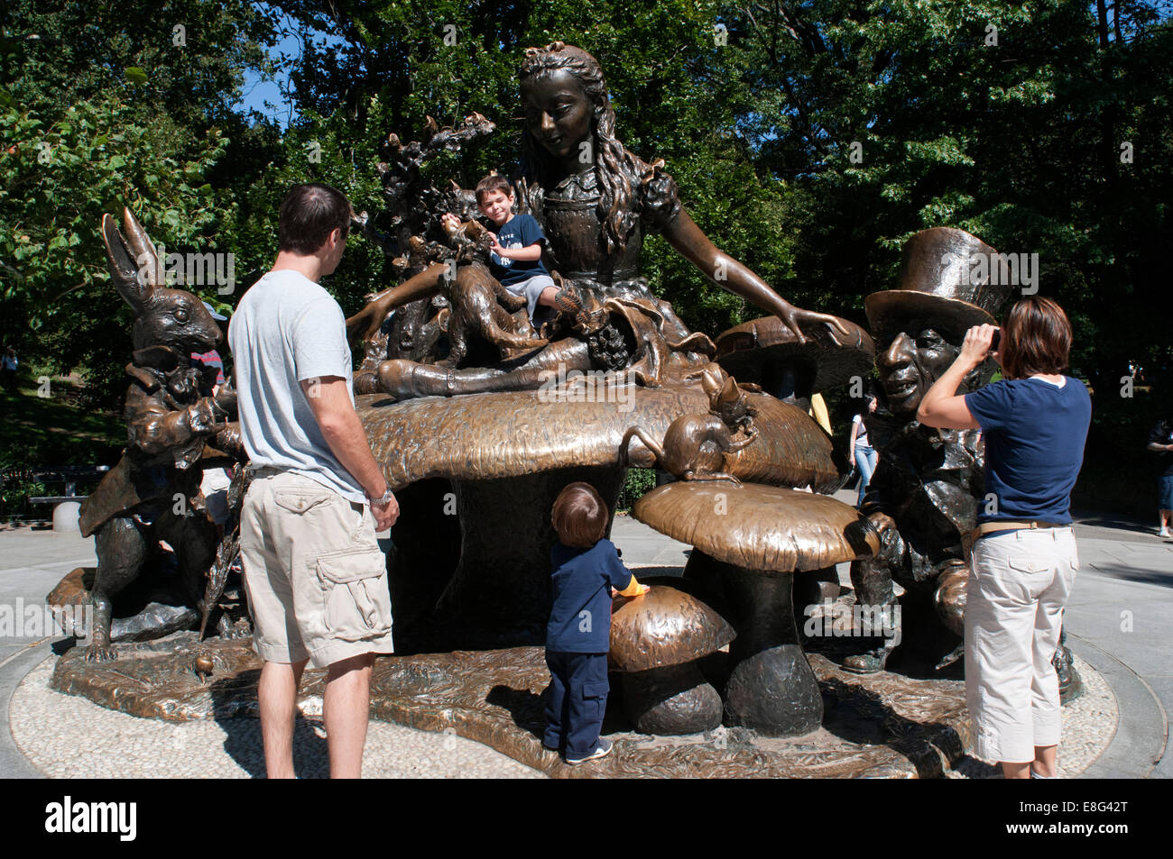 Children playing on Alice in Wonderland monument, Central Park, New York City. Alice and her cast of storybook friends found the Stock Photo