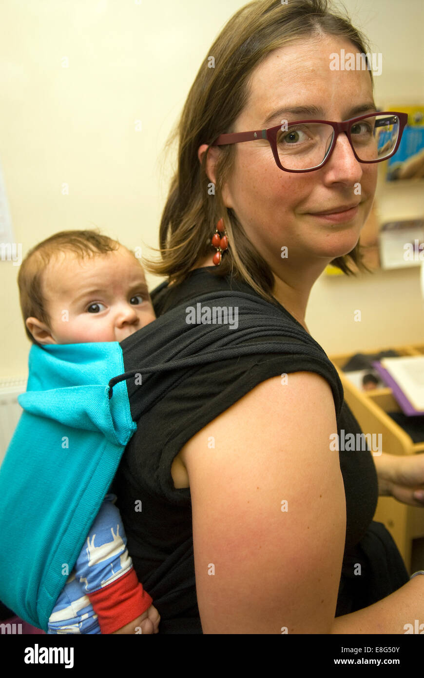 Young mother carrying her 3 month old son in a baby sling, Farnham, Surrey, UK. Stock Photo