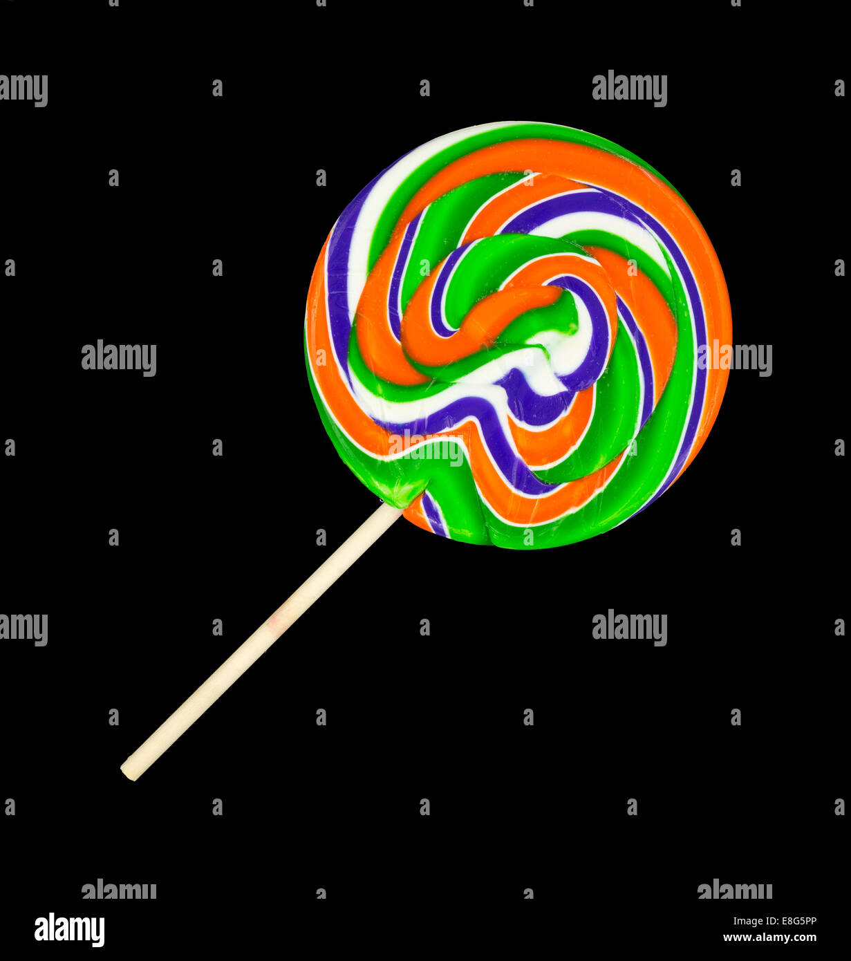 A very colorful orange, green, blue and white lollipop with a wood stick handle on a black background. Stock Photo
